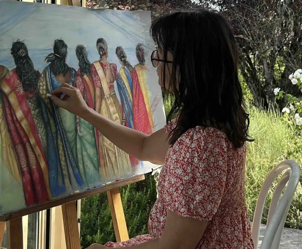 Sylvie Sanséau artiste pastelliste peint des indiennes en sari devant la mer dans son atelier